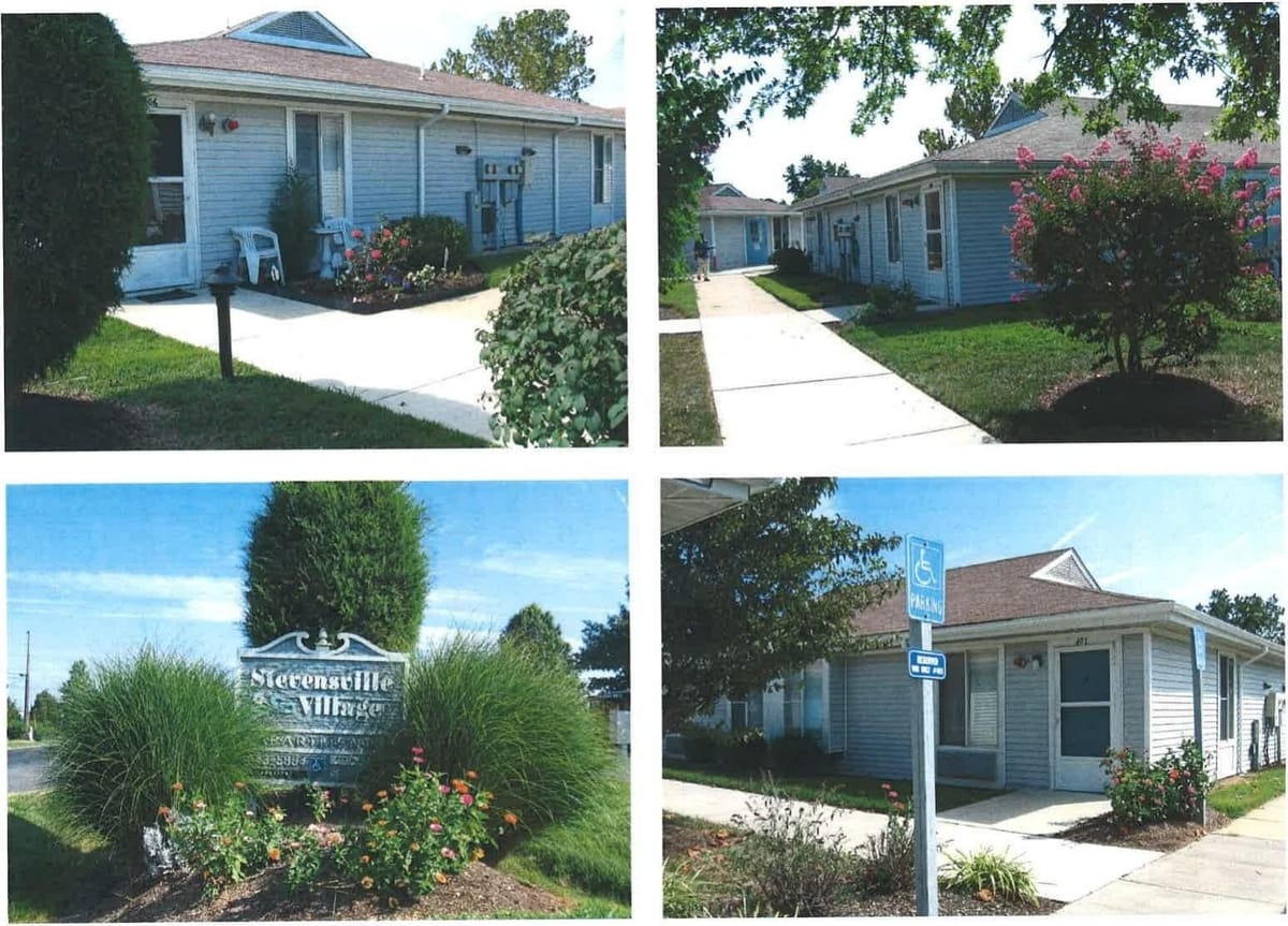 Landscaped walkways and single-story Stevensville Village buildings with blooming crepe myrtle and flower beds